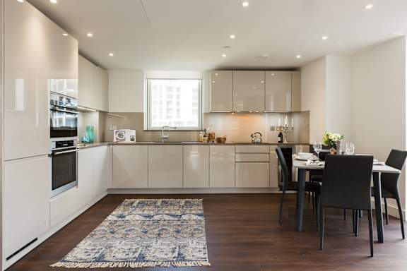 a kitchen with white cabinets and a table and chairs