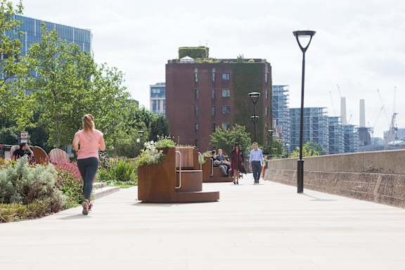 people walking and running on a sidewalk in the city