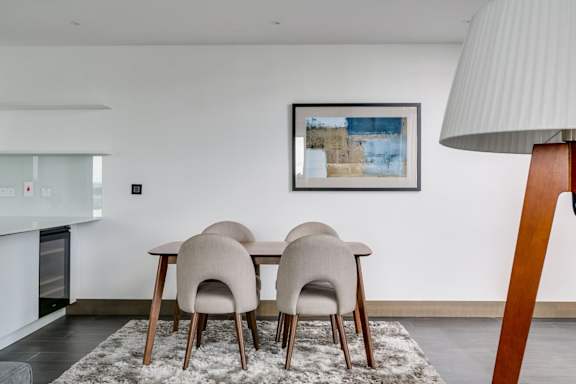 a dining room with a table and chairs and a painting on the wall
