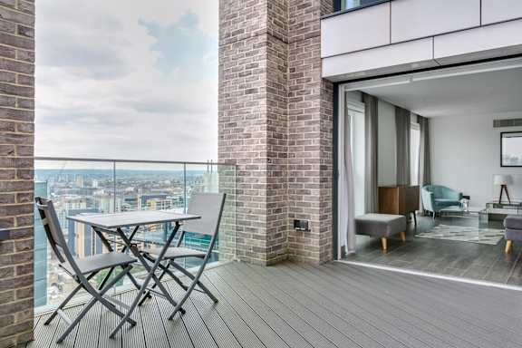 a balcony with a table and chairs and a window