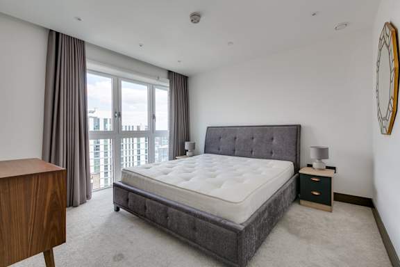 a bedroom with a bed and a large window