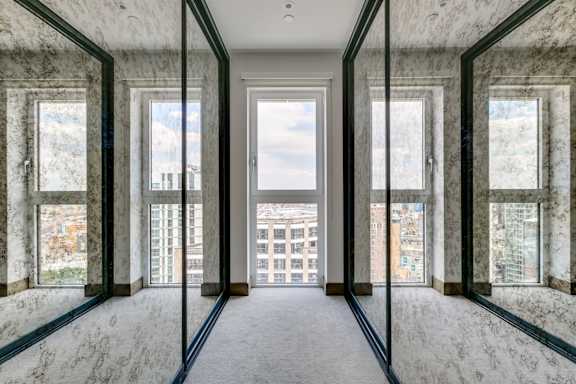 an empty room with windows and a view of the city