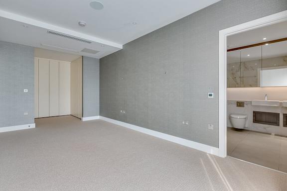 a large empty room with a bathroom and a toilet
