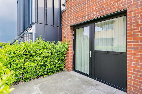the front door of a brick building with a glass door