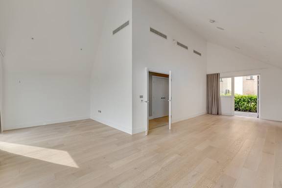 A room with wooden flooring and white walls.