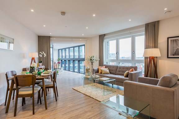 a living room and dining room with a table and chairs