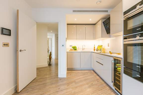 a kitchen with white cabinets and a wooden floor