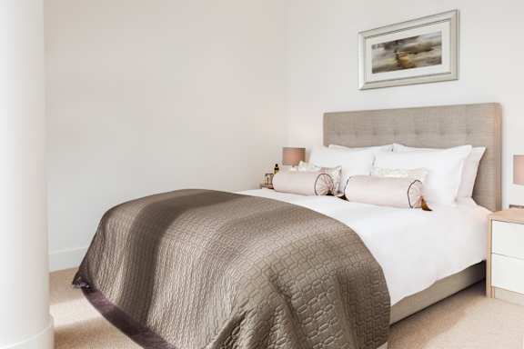 a bedroom with a bed and a painting on the wall