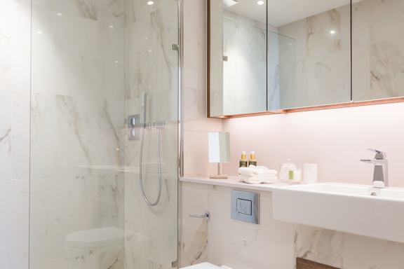 a bathroom with a shower and a sink and a mirror