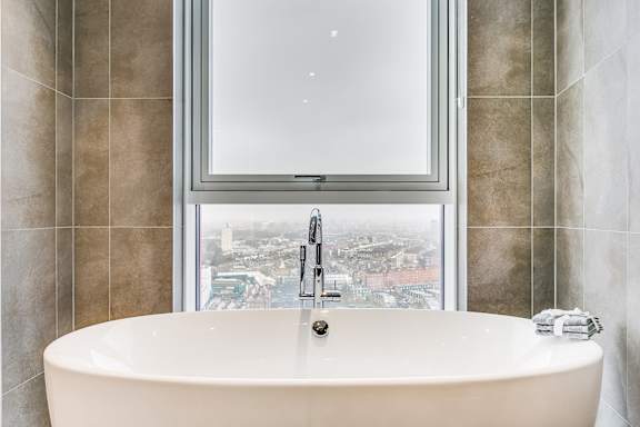 a white bath tub in front of a window