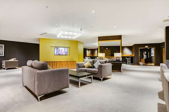 a living room with couches and chairs and a yellow wall