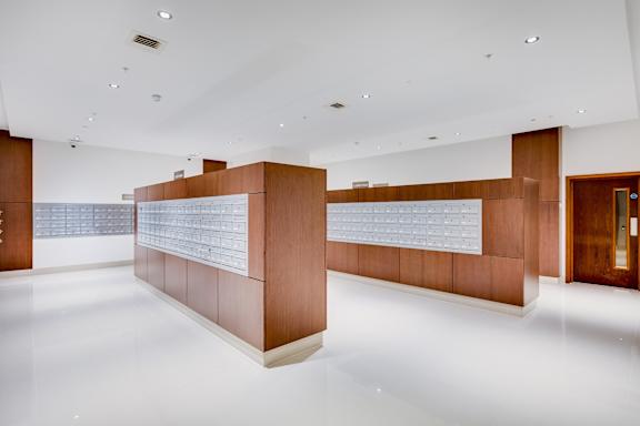 a large white room with a large wooden reception desk in the middle