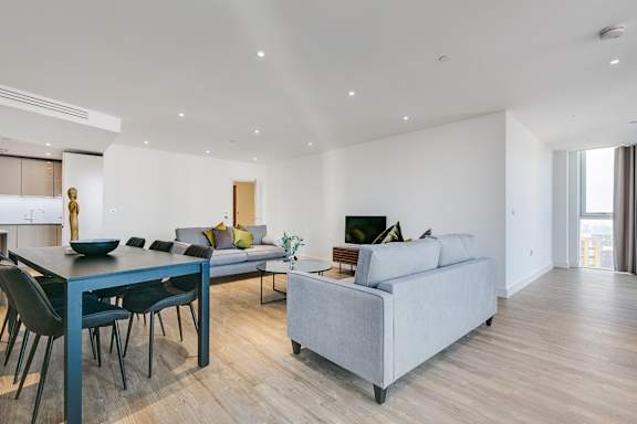 a living room and dining room with couches and a table