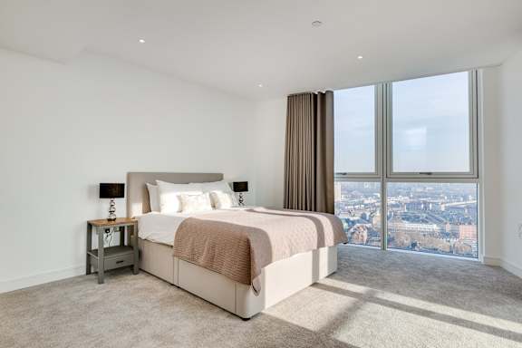 a bedroom with a large window and a bed