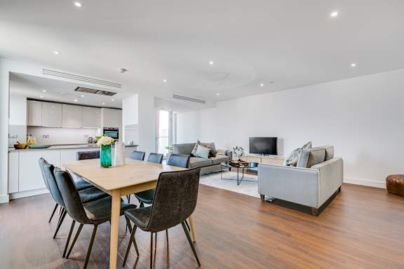 a living room with a kitchen and a dining table