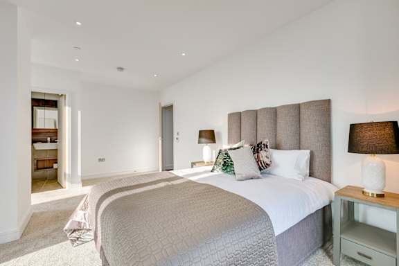 a bedroom with a large bed and a door to a bathroom
