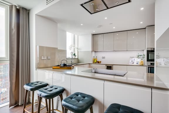 a kitchen with a counter top and three stools