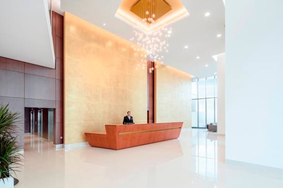 a man sitting at a desk in the lobby of a building