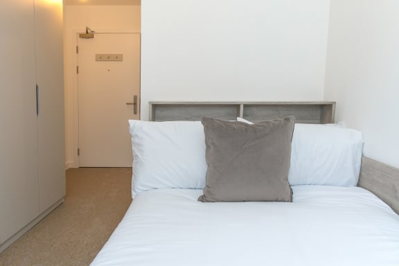 a bedroom with a bed with two pillows and a door