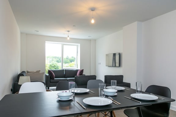 a living room with a table and chairs and a large window