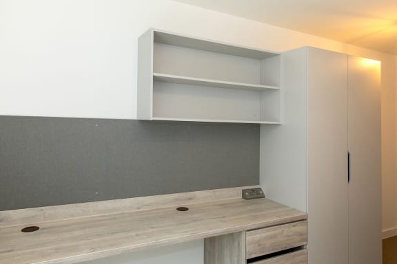 a kitchen with white cabinets and a counter top and a shelf