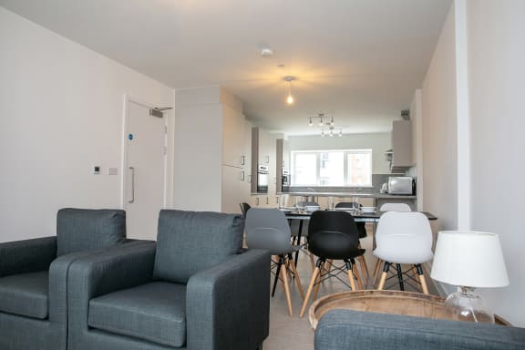 a living room with couches and a table with chairs