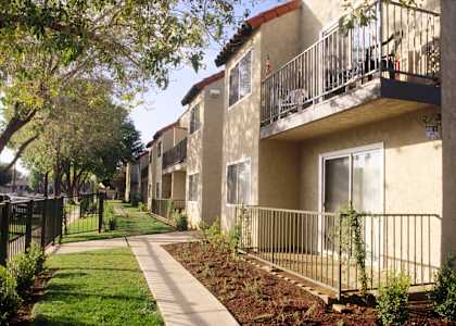 a row of apartments with balconies and a sidewalk