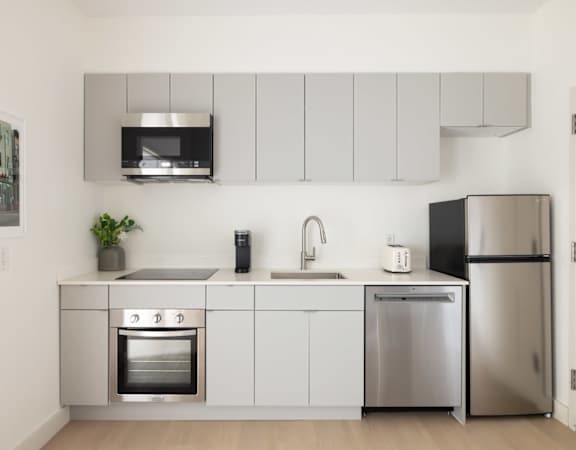 A modern kitchen with stainless steel appliances and white cabinets.