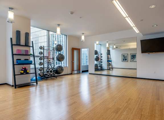 A gym with a mirror, weights, and exercise equipment.