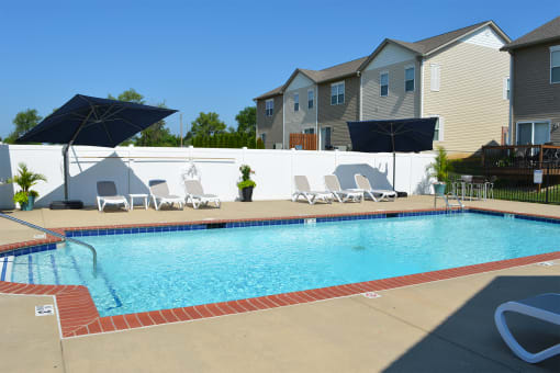 Outdoor pool with lounge chair seating and umbrellas