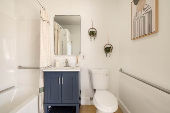 A bathroom with a white toilet and a blue cabinet.