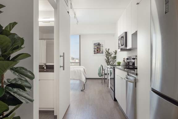 A modern kitchen with stainless steel appliances and a dining area with a view of the city.