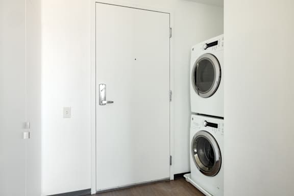 A white door with a handle and a white wall with a switch.