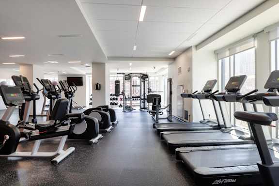 A gym with treadmills and elliptical machines.