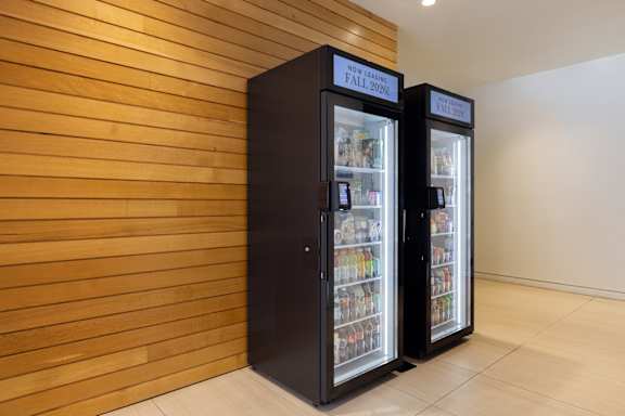 Two black vending machines with the words "NOW SELLING" on them.