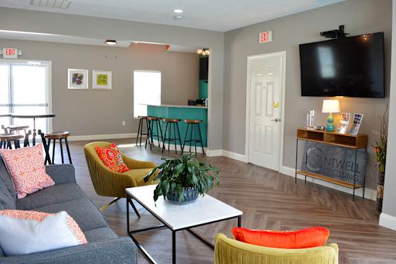 Cantwell crossing clubhouse living room with couches, chairs, coffee tables, and television