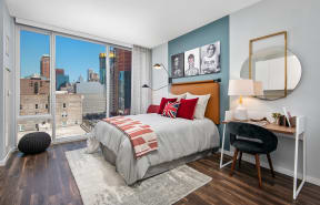Furnished studio bedroom with floor to ceiling windows at Eleven40 in Chicago, IL