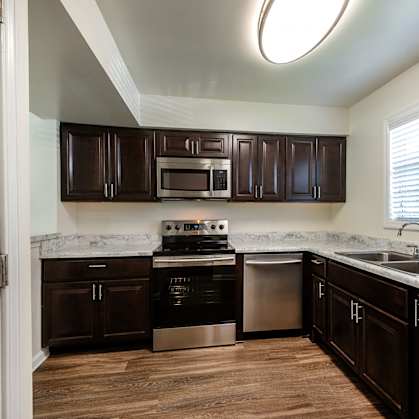 A kitchen with dark brown cabinets at Fords Pointe Apartments in Savannah GA
