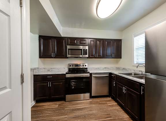 A kitchen with dark brown cabinets at Fords Pointe Apartments in Savannah GA