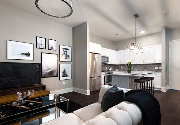a living room with a white couch and a kitchen
