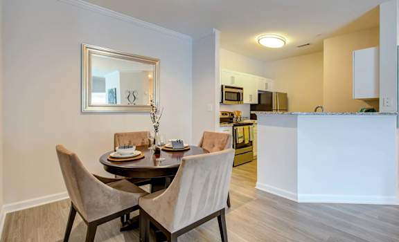a dining room with a table and chairs next to a kitchen at Thornberry Apartments, Charlotte, 28262