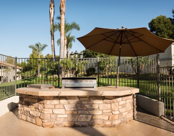 a fire pit with an umbrella in a backyard