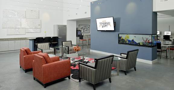 a large lobby with chairs and tables and a tv at Tindeco Wharf, Maryland, 21224