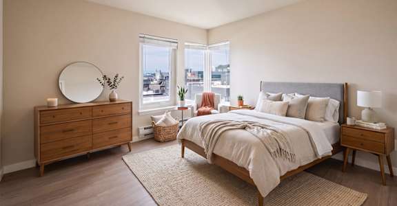 A bedroom with a large bed, a dresser, and a mirror.