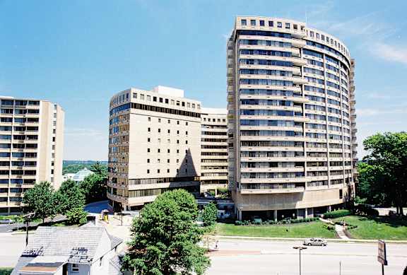 A large building with a curved top is in the middle of a parking lot at Hampton Plaza Apartments, Towson, MD, 21286