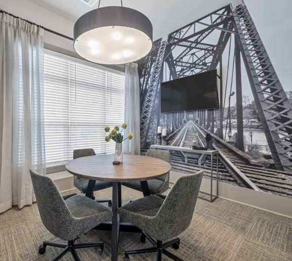 a room with a table and chairs and a large picture of a bridge