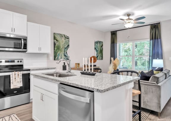 an open kitchen and living room with a counter top at Claret Village at LaFayette Trail, Tallahassee, FL