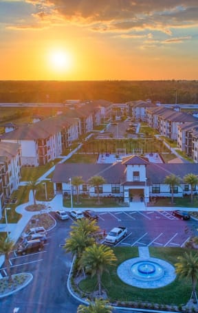 an aerial view of an apartment complex with a sunset in the background