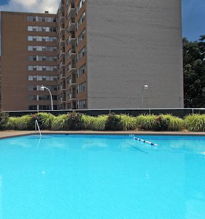A swimming pool in front of a tall building.