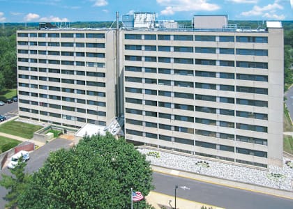 an aerial view of a large office building with trees and a road